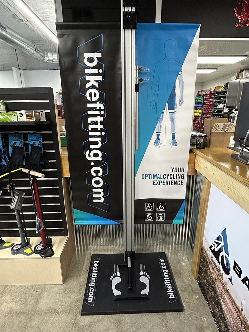 Bike fitting specialist using 2D motion analysis software while rider pedals on indoor trainer