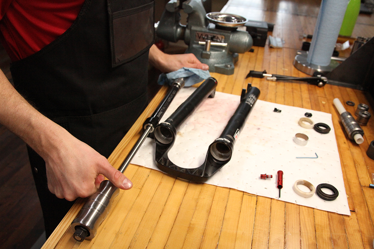 Bike mechanic working on suspension fork tuning at Basecamp Bike Shop